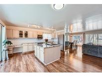 Bright kitchen with light cabinets, granite countertops, stainless steel appliances, and wood floors at 4090 S Tamarac Dr, Denver, CO 80237