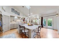 Bright kitchen with a skylight, marble island, stainless steel appliances, and bar stool seating at 6503 Big Horn Trl, Littleton, CO 80125