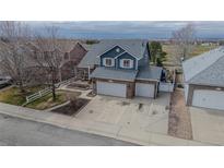 Attractive two-story home with a well-maintained lawn, brick accents, and a three car garage at 319 Mountain View Ave, Fort Lupton, CO 80621