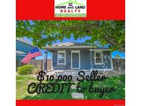 Charming single-story home featuring a cozy front porch, complemented by an American flag and lush green lawn at 2791 Quarterland St, Strasburg, CO 80136