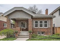 Charming brick home featuring a covered front porch with seating area at 1023 S High St, Denver, CO 80209