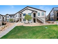 Inviting townhouse with a well-maintained lawn and exterior stairs leading to the entrance at 4500 Copeland Cir # 104, Highlands Ranch, CO 80126