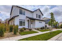 Charming two-story home featuring white siding, black accents, and a well-maintained front yard at 10136 Worchester St, Commerce City, CO 80022