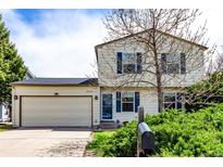 Charming two-story home featuring a two-car garage and a well-maintained front yard with mature landscaping at 10720 Moore Cir, Westminster, CO 80021