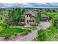 Stunning home with stone accents, a well-manicured lawn, and beautiful landscaping at 5424 Hacienda Pl, Parker, CO 80134