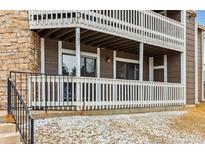 Exterior shot of a brown condo building with white railing on the balconies and stone facade at 18004 E Ohio Ave # 101, Aurora, CO 80017