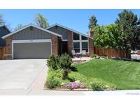 Charming brick home with a well-manicured lawn, flower beds, and an attached two-car garage at 8101 S San Juan Range Rd, Littleton, CO 80127