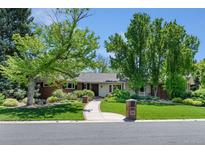 Charming single-story home featuring a brick exterior, lush landscaping, and a welcoming walkway at 3980 S Dexter St, Cherry Hills Village, CO 80113