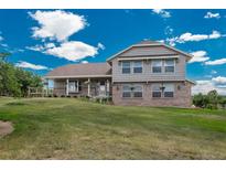Charming two-story home featuring a well-maintained lawn, brick accents, and flower boxes under the windows at 3488 Dawson Rd, Sedalia, CO 80135