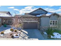Charming home featuring a stone and siding exterior, complemented by a two-car garage and well-maintained landscaping at 3565 New Haven Cir, Castle Rock, CO 80109