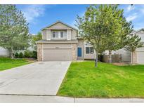 Charming two-story home featuring a blue front door, attached garage, and well-manicured lawn at 22974 E Dorado Dr, Aurora, CO 80015