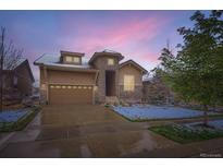 Charming home featuring a stone archway, two-car garage, and well-maintained landscaping at 15855 Wild Horse Dr, Broomfield, CO 80023