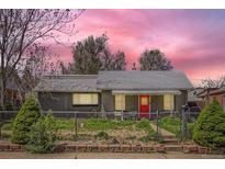 Charming single-story home with red front door and front yard with chain link fence at 1629 Valentia St, Denver, CO 80220