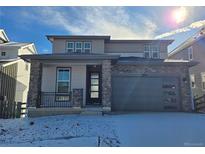 Charming two-story home featuring stone accents, a covered porch, and an attached garage at 8816 Whiteclover St, Littleton, CO 80125