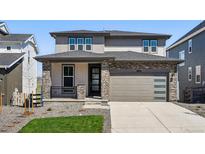 Charming two-story home with stone accents and a well-maintained front yard and modern garage at 8816 Whiteclover St, Littleton, CO 80125