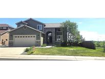 Beautiful two-story home with stone accents, a two-car garage, and a well-manicured front lawn at 21580 Longs Peak Ln, Parker, CO 80138