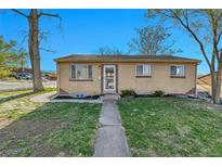 Charming single-story brick home with a well-maintained lawn and inviting front entrance at 611 Winona Ct, Denver, CO 80204