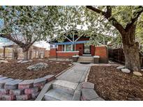 Charming brick home featuring a landscaped front yard, stone walkway, and flowering trees at 241 N Grant St, Denver, CO 80203