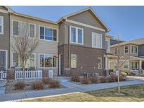 Charming two-story townhome with brick accents, inviting entrance and manicured lawn at 15530 W 64Th Pl # C, Arvada, CO 80007