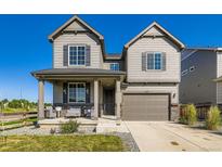 Charming two-story home with a covered front porch and attached two-car garage in a desirable neighborhood at 607 Azalea St, Brighton, CO 80601