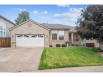 Charming brick home with a well-manicured lawn and attached two car garage at 11237 W Ford Dr, Lakewood, CO 80226