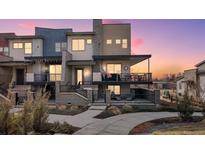 Charming townhome featuring two stories, outdoor balconies, and a beautifully landscaped front yard during a colorful sunset at 1039 Leonard Ln, Louisville, CO 80027