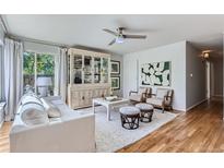 Bright living room featuring hardwood floors, comfy seating, and large windows at 4727 E Bails Pl, Denver, CO 80222