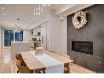 Bright dining area featuring a fireplace, modern lighting, and hardwood floors, adjacent to the kitchen at 3232 W 16 Ave, Denver, CO 80204