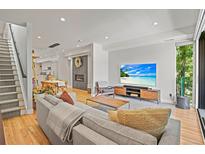 Bright living room boasts modern finishes, a stylish fireplace, and an open floorplan with hardwood floors throughout at 3232 W 16 Ave, Denver, CO 80204