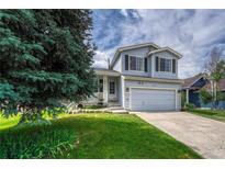 Charming light blue two-story home with a well-manicured lawn and attached garage at 21789 Farmingdale Way, Parker, CO 80138