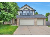 Charming two-story home featuring a three-car garage, manicured lawn and covered porch, perfect for curb appeal at 18852 E Progress Ave, Centennial, CO 80015