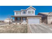 Charming two-story home featuring a welcoming front porch, stone accents, and a well-maintained lawn at 13903 Hillsboro Dr, Parker, CO 80134