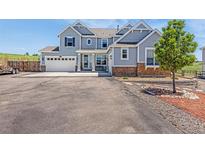 Charming two-story home featuring stone accents, a three-car garage, a manicured lawn, and a spacious driveway at 3434 Antelope Ridge Trl, Parker, CO 80138