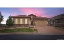 Beautiful single Gathering home featuring a stone and stucco exterior with a meticulously maintained front yard at 10646 Winding Pine Pt, Highlands Ranch, CO 80126