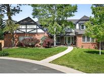 Charming brick Tudor-style home featuring well-manicured landscaping and a welcoming entrance at 5441 S Dayton Ct, Greenwood Village, CO 80111