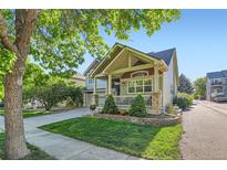 Charming home featuring a well-maintained lawn and a welcoming front porch with stone accents and a manicured garden at 301 Harvest St, Longmont, CO 80501