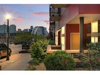 Modern condo building with city views, red siding, and landscaped entrance at dusk at 2518 16Th St, Denver, CO 80211