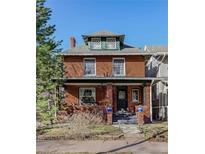 Charming two-story brick home with a covered front porch and lush landscaping at 231 N Sherman St, Denver, CO 80203