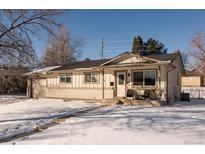 Charming single-story home with a brick facade, covered porch, and snow-covered yard at 757 S Wheeling St, Aurora, CO 80012