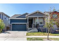 Charming two-story home with a covered porch, well-maintained lawn, and an attached two-car garage at 20936 E 61St Ave, Aurora, CO 80019