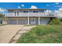 Two-story home featuring a balcony, three-car garage, and well-maintained lawn at 15805 W 14Th Pl, Golden, CO 80401