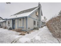 Charming townhome featuring a snow-covered roof, blue trim, and a welcoming entrance at 2504 S Victor St # E, Aurora, CO 80014