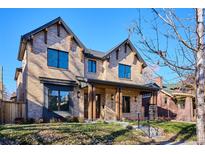 Stunning two-story brick home showcasing modern architectural design, warm wood accents, and manicured front lawn at 457 S Vine St, Denver, CO 80209