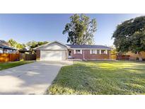 Charming single-story brick home with a well-manicured front yard and a two-car garage at 820 Cottonwood Ave, Centennial, CO 80121