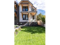 Two-story modern home with dark brick and white siding, showcasing a grassy yard at 2478 S Lafayette St, Denver, CO 80210