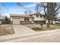 Charming split-level home with attached garage, mature trees, and a welcoming front yard at 478 S Lima Cir, Aurora, CO 80012