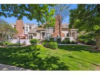 Inviting townhome with mature trees, lush lawn, and a charming white picket fence at 2883 W Long Cir # E, Littleton, CO 80120