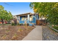 Charming bungalow with blue exterior, landscaped yard, and walkway at 4922 Meade St, Denver, CO 80221