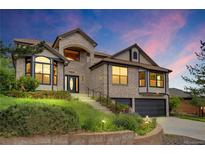Charming two-story home with lush landscaping, brick facade, and attached two-car garage at 5569 Willow Springs Dr, Morrison, CO 80465