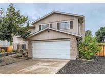 Charming two-story home featuring a two-car garage and brick accents surrounded by well-maintained landscaping at 3235 S Newland St, Denver, CO 80227
